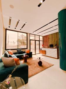 达赫拉TIMAZIN HOTEL DAKHLA的一间带绿色沙发的客厅和一间厨房
