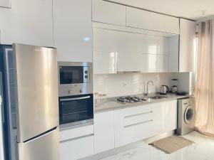 普拉亚Apartamento sublime c/vista top.的白色的厨房配有白色橱柜和电器