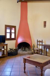 查兹拉德拉谢拉Paraje del Hueznar的客厅设有砖砌壁炉和桌子