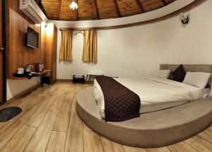 博尔本德尔Unique Resort And Restaurant的圆形客房中一间带一张大床的卧室