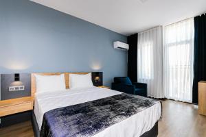 安塔利亚拉瑞世界酒店的一间卧室设有一张大床和蓝色的墙壁