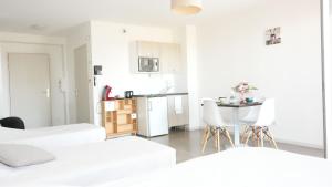 YzeureZenao Appart'Hotel的白色的公寓,设有厨房和桌椅