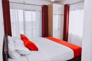 Tatu CityElegant apartment in TATU CITY的一间卧室配有红色和白色枕头的床