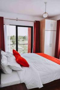 Tatu CityElegant apartment in TATU CITY的一间卧室配有一张带红色枕头的床
