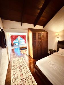 金马仑高原The White Horse的一间卧室设有一张床,一扇门通往客厅