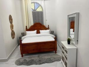 NgamboNashu House Stone Town的一间卧室配有木床和镜子