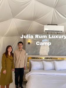 瓦迪拉姆Julia Rum Luxury Camp的站在床边的男人和女人