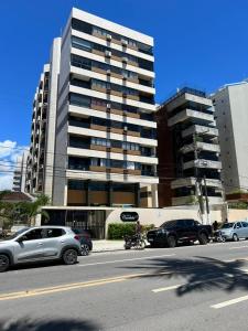 马塞约Apt Praia bela,Edificio casa bela,pajucara 77的一条城市街道,汽车停在高楼前