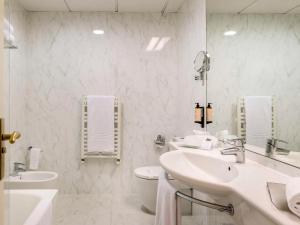 洛格罗尼奥卡尔顿里奥哈美居酒店的白色的浴室设有2个盥洗盆和1个卫生间。
