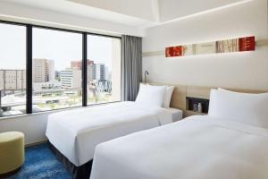 金泽Hyatt House Kanazawa的配有大窗户的酒店客房内的两张床