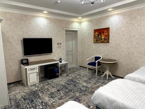 UzbankintyGulnora HOTEL的酒店客房设有一张桌子和一台墙上的电视。