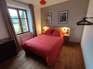 FraizeLogement Spacieux的一间卧室配有一张带红色床单的床和一扇窗户。