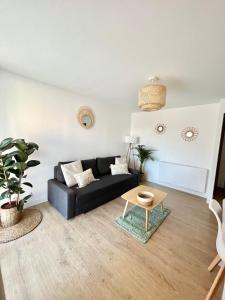 阿格德角Appartement Cosy - Cap d'Agde proche plage et port - Parking的客厅配有黑色沙发和桌子
