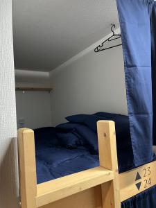 广岛広島ゲストハウス Nice Day的一间卧室配有带蓝色床单的双层床