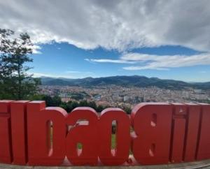 毕尔巴鄂Hotel Artxanda Bilbao的享有城市美景的红色标志