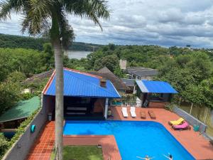 伊瓜苏港Guembe al Rio Hostel的享有带游泳池和棕榈树的别墅的空中景致