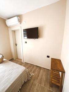 格克切达镇GÖKÇEADA BADEMİ BUTİK OTEL的卧室配有一张床和壁挂式平面电视。