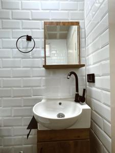 格克切达镇GÖKÇEADA BADEMİ BUTİK OTEL的浴室设有白色水槽和镜子