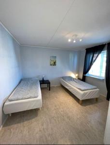 恩舍尔兹维克Rentalux Apartments in Örnsköldsvik的一间卧室设有两张床和窗户。