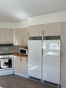 恩舍尔兹维克Rentalux Apartments in Örnsköldsvik的厨房配有白色冰箱和微波炉