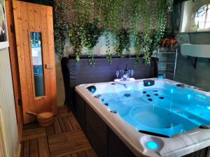 圣布里厄Le Jardin Secret & Spa的植物浴室内的按摩浴缸