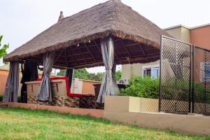 AbeokutaÌtùnú at Molara's Villa的一个带草屋顶的凉亭
