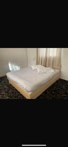 Buq‘ātāEVAN PARK的一张位于带白色床垫的房间内的床铺