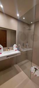 马拉喀什阿尔马斯酒店的带淋浴、盥洗盆和镜子的浴室