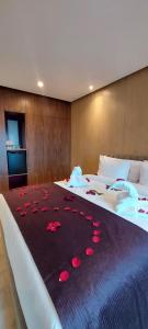 马拉喀什阿尔马斯酒店的一间卧室配有两张床,床上铺有红色玫瑰花瓣。
