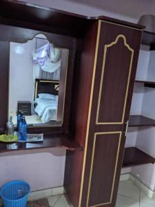 内罗毕Madola Hotel的小房间设有镜子和一张床