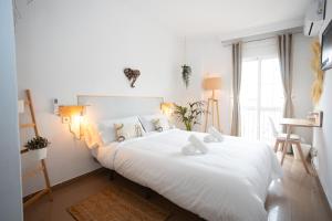 内尔哈Naim Guest House Nerja的卧室配有白色床单和白色大床