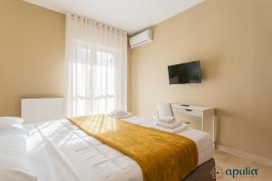 巴里Fifty-One Guesthouse by Apulia Accommodation的卧室配有一张床,墙上配有电视。
