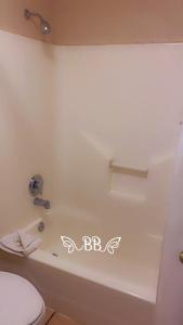Elmendorf布朗宁湖戴斯套房酒店的浴室配有白色浴缸和卫生间。