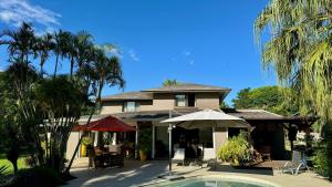 塔马兰Villa Petit Tamarin : piscine bar et grand jardin tropical的一座房子前面设有游泳池
