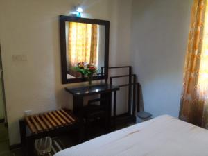 贾夫纳Nothern Residence的一间卧室配有一张床、镜子和椅子