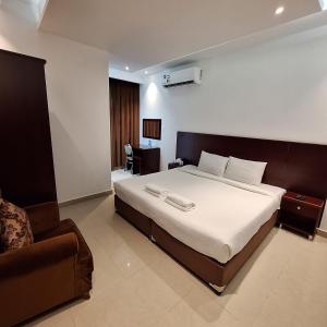 锡卜ALJAWHARA INN HOTEL的一间卧室配有一张大床和一张沙发