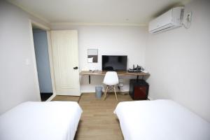 首尔Hotel Golden Hill的客房设有两张床和一张带电脑的书桌