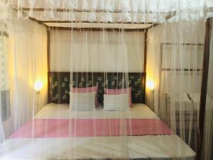 坦加拉Sumudu Modern Villa的卧室配有带白色窗帘的天蓬床