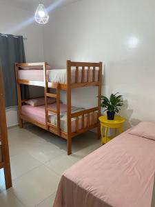 乌巴雅拉Apuama Hostel的一间卧室设有两张双层床和盆栽植物