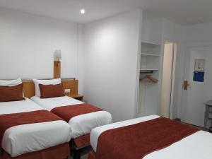 鲁昂莫朗酒店的酒店客房,配有两张带红色床单的床