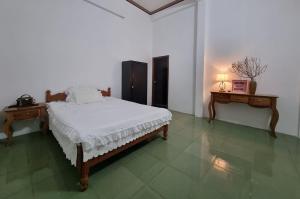 Ðông Mỹ (2)Katie's homestay的一间白色卧室,配有一张床和两张桌子