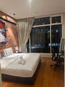 吉隆坡Soho Suites KLCC By Inam Suites的一间卧室设有一张床和砖墙