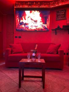 松德里奥Casa Vacanza Relax Sondrio的红色的客厅配有红色的沙发和桌子