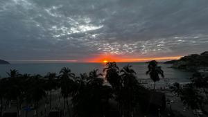 圣玛尔塔Vista increíble Chirama Rodadero的棕榈树海滩上的日落和海洋