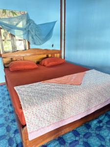Muang KhôngHappy bangalow riverside的一间卧室配有两张木制床和红色枕头