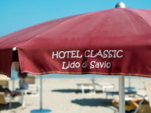 丽都迪萨维奥Hotel Classic的红色的伞,带有素瓦霍经典丽都酒店