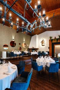 圣维特斯坦恩维尔酒店的用餐室配有白色的桌子和蓝色的椅子