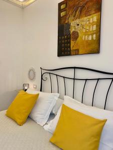 塔兰托Bien-être Exclusive Apartment的一间卧室配有一张带黄色枕头的床和一幅画