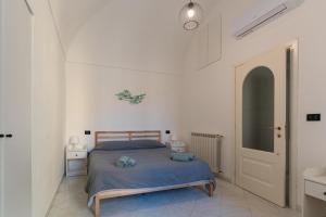 阿拉西奥Case da Amare - Vista mare a 30 metri dalla spiaggia的一间白色客房内的床铺卧室
