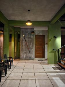 达瓦拉维Royal Tusker Hotel的一间设有绿色墙壁和木门的房间